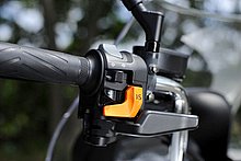 オレンジ色のI-Sスイッチは、ライダーが任意でシフトダウンを行うためのもの。スイッチ操作により、アクセル開度やエンジン回転数などさまざまな情報から電子制御式CVTの変速比を変更し、エンジン回転数を上昇させる。この機能は、3つの走行モードいずれでも使用可能だ。そのスイッチ下のレバーは、パーキングブレーキ。料金所など両手を離した状態で車両を停車するときに使用する。