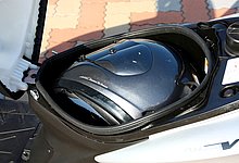 シート下のヘルメットスペースは、メットを横にして入れるタイプ。なお、シート前方に見える銀色の突起はヘルメットホルダー。