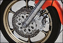 フロントもアクティブ社の鍛造アルミ製18インチに100/90-18インチのダンロップ TT900GP。キャリパー／ローター共にPM 社製。