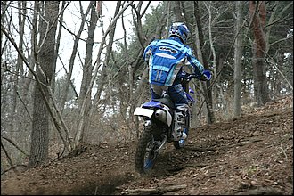 ②前輪がギリギリ木の根を避けるラインを選んだため、斜面に対してバイクが少し寝てしまった。