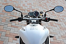 テーパー加工が施されたアルミハンドルバーは、国産ネイキッドに比べるとやや幅広でかなり低い位置にセットされている。タンクも短くなりライポジはよりコンパクトに。