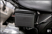 車体左側に露出しているバッテリーの本体色は黒色で、電解液のレベル確認はできない。端子部分を保護するスチール製カバーは、バッテリー本体の固定バンドを外すと取れる。
