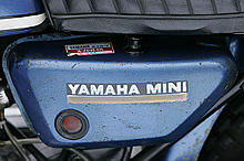 サイドカバーのようなオイルタンクにはYAMAHA MINlのロゴが入る。オイルタンク上面のコーションやロゴデカールは当時のままでコンディションも良好だ。