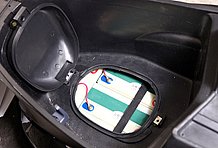 シート下スペースのフタを開けるとバッテリーが。樹脂のフタがしっかり開閉できるかチェックします。フタがちゃんとしまらないと水が入る事も！