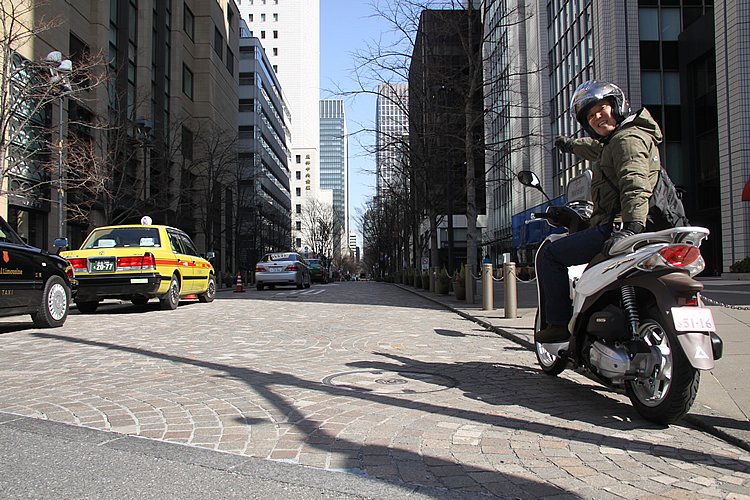 丸の内仲通りは一方通行。広い車道と両側の歩道、すべてが石畳となっている