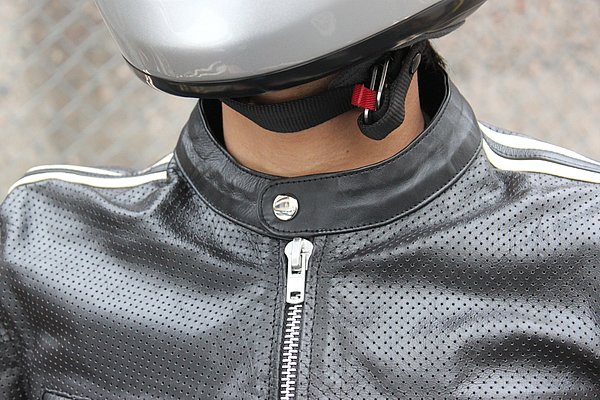 スタンドカラー（立ち襟）は、シングルライダースの特徴の1つ。首元からの風の侵入を防ぐ襟ボタンはスナップボタン式を採用。グローブをはめたままでも外したり付けたりすることができる。