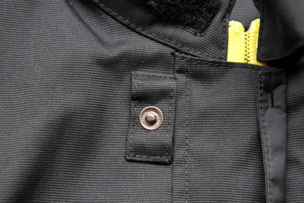 襟元に近い第1ボタンは、布を独立させたフローティング構造のため、ヘルメットをかぶったままでも指で簡単にボタンの位置を探せる親切な設計。もちろんボタンの留め外し動作も容易だ。