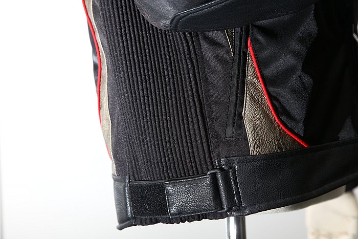 脇部分はシャーリング加工されており、フリースやダウンなどをインナーとして着用する際もジャケットのフィット感を維持してくれるし、ライディング以外の行動時でも動きやすい。