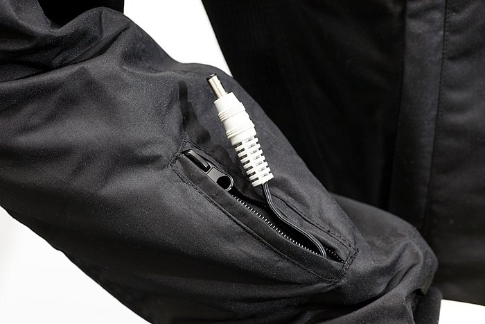 両腕の袖口付近には、別売のヒーティンググローブを接続するための電源コードが内蔵される。使用しないときはポケットに収納できるので邪魔になることはない。コード長は約15cmだ。