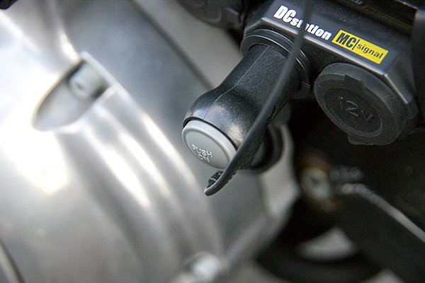 付属のコード類で電源確保も簡単。写真はバイクに設置したシガーライターソケットに接続した例。プラグにオンオフスイッチがあるのでとても便利だ。