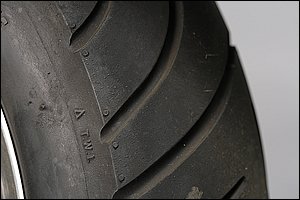 タイヤの磨耗具合はタイヤのサイドウォールに刻印された三角マークを規準にトレッド部の溝内の凸マーク「スリップサイン」を確認して判断します。このスリップサインがトレッド面とつら位置になったらタイヤは寿命です。