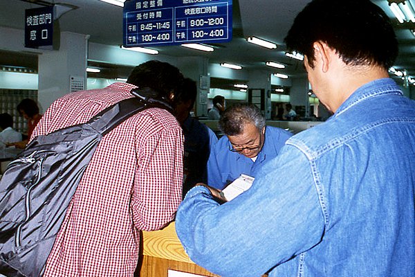 書類の準備が全て終わったら、ユーザー車検の検査受付窓口で、予約確認を行なおう。受付は検査時間の初めから随時行なっているから、書類ができた時点で行けばよい。ここでは書類の記入ミスや不備がないことなどを確認し、これが大丈夫となったら電話予約の際にアンサーシステムが決めた予約番号を尋ねられるので、ちゃんと答えよう。この時点では、予約者の情報は予約番号でしか管理されていないので、番号を忘れたからといって名前や住所を告げても、予約者本人かどうかの確認ができないので気を付けよう。