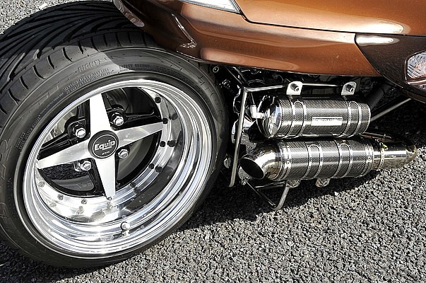 迫力の四輪車用タイヤ＆ワイドホイールをはじめ、同ショップサイレンサーを使ったマフラーも全てワンオフ。マフラーのすぐ上にマウントしているカーボンのサイレンサー風の筒は、実はエアタンクとして機能する。
