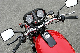 フロントフォークと上下ブラケットはGSX1100Sカタナ用を加工して装着する。本来、カタナはセパレートハンドル車だが、トップブリッジ上にアントライオン製ポストを設置することでバーハンドル化している。ライトステーもワンオフで、タンデムステップ同様に全体のすっきり感演出にひと役買う