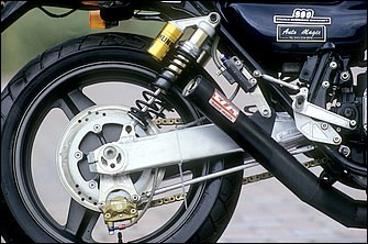 リヤホイールはCB1000SF用だが、STDの丸パイプ鋼管から角型となったスイングアームはゼファー750流用。リヤショックはオーリンズ製で、レイダウンマウントされる。リヤブレーキキャリパーにブレンボ製の通称“カニ”対向2ピストンを使うのもこの頃に定番化した