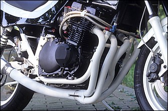 80年型GSX1100E（72×66mm、1075cc。スペックも形状も'81～GSX1100Sとほぼ同じ）のエンジンは、ヨシムラ製φ74mmピストンで1135cc化。圧縮比は12.5：1で、カムはヨシムラST-2。キャブはTMR-MJNφ40mmで、EXはヨシムラのレース用4-1だ。軽量化されたバルブや独自加工のシリンダーヘッドは、浅川さんならではの作り