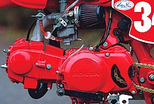 真っ赤にペイントされたエンジンは、デイトナ製キットで95ccにボアアップ。ジェネレーターカバーのスプロケット部分は、オフロード走行を考え、穴あけ加工が施される。