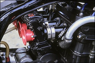 本来ダウンドラフト吸気のZZR1100エンジンをGPZ-Rに積むため、吸入ポートはホリゾンタル化。マニホールドはアルミ単品製作で、ブラックボディのキャブはFCRφ39mm。これらを装着するため、燃料タンク裏面は逃げ加工