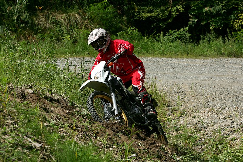 アクセルを開け足したことでリアタイヤがスリップ。ハンドルも切れ込み、バイクが倒れかけてもはや修正不能に…。