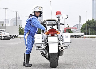 体力・体格面でハンデのある女性でも技術を身につければ、このように体をバイクから離して後進することもできる。上体とともに足先を進行方向に向けると押しやすい。