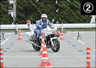 スロットル操作に連動しつつ内ヒザ(この場合は左足)で車体を起こしつつ外足(この場合は右足)でステップを踏み込む。各パイロンの中間地点を前輪が通るイメージ。