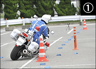 白バイが訓練で行う８の字は走路がマーカーで規制されているのが特徴。コーナー入口では前後ブレーキをフルに使いつつ車体を傾けながら進入していく。