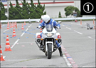 片側1車線の狭い道路でのＵターンを想定した「小道路旋回」。振り返って目視し、競技では後方に出されたプラカードの車種を大声で確認。前後ブレーキはかけておく。