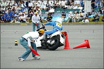 パイロンタッチも減点対象。白バイは張り出したバンパーなどがあるため、内輪差を計算したシビアな車両感覚とライン取りが求められる。審判員は些細なミスも見逃さない。