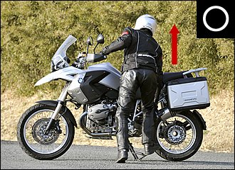 センタースタンドをかけるときは、なるべく体をバイクに近づけるのがコツ。スタンドの2ヶ所がしっかり路面に接していることを確認し、体重をすべて載せるつもりで踏み込みつつ引き上げます。爪先を後に向けておくと力を入れやすいですよ。