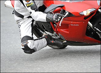 バイクのデザインは一見左右対称に見えますが、操作系はまったく異なります。特に右側にはアクセルと前後ブレーキなどの速度調整に関わる大事な操作系が集中しているため、扱いが難しくなっています。その中でもとりわけ操作方法に工夫が求められるのがリアブレーキ。たとえば旋回中に軽くリアブレーキを当てて姿勢を安定させたい場合など、左コーナーの場合は土踏まずをステップに載せておけば普通に操作出来ますが、右コーナーは少々厄介。ハングオフフォームのときは、写真のように足裏を車体側に向けるイメージで、小指の外側などを使ってペダルを操作してみると良いでしょう。いずれにしても、慣れは必要です。