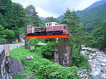 県道３号線を北上して６分ほど走ると、一部が残された森林鉄道の橋梁に小さな機関車が置いてあります。森林鉄道跡がキャンプ場になっています。