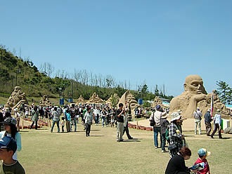 世界10カ国から参加した有名な砂像彫刻家10人とスタッフの製作した砂像と見惚れ楽しむ人々。会場内には砂像選手権に参加しない作品も数体展示されている。