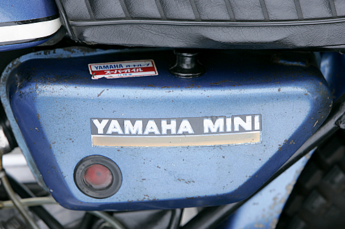 サイドカバーのようなオイルタンクには「YAMAHA MINI」のロゴが入る。この個体のタンク上面のコーションやデカールは当時のオリジナルだ。